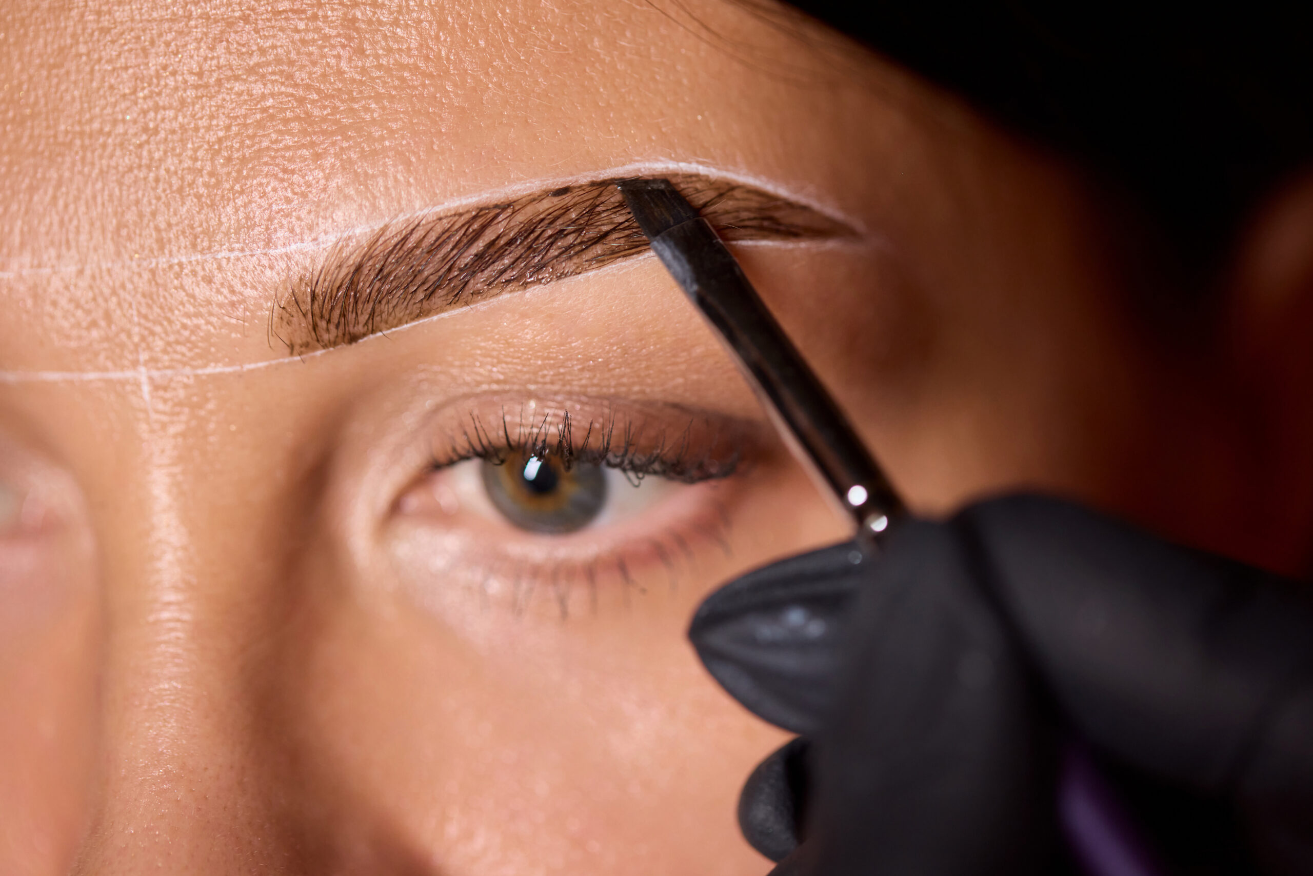This is a closeup view demonstrating an eyebrow grooming technique that utilizes a wooden stick for precision